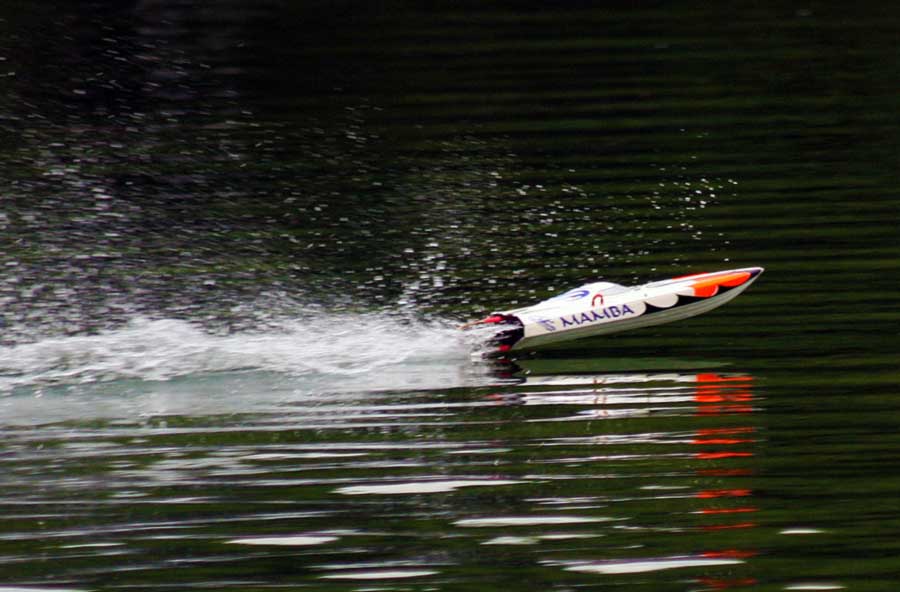 MHZ Powerboats Mamba Mono Rennboot -Modell in weiß/orange Auf see über Welle springend